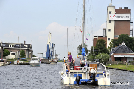 Fr zuivelverwerkende fabriek van Vreugdenil BV torent hoog uit boven het dorp Scharsterbrug, dat doorsneden wordt door de Scharsterrijn, het water tussen het Tjeukemeer en de Langweerder Wielen.