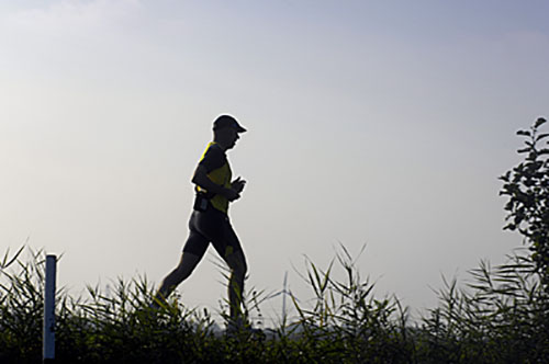 Een eenzame jogger draaft over de Birstumerdijk onder Nes bij Akkrum. 