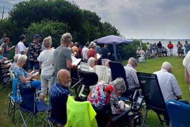 Tachtig bezoekers samen met kipspiesjes, hamburgers en muziek